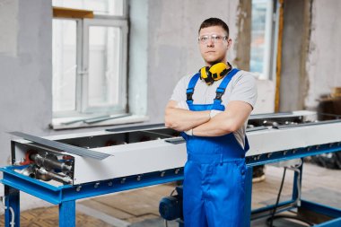 Mavi üniformalı profesyonel mühendis fabrikada çalışıyor. Yuvarlak metal, metal işleme ve metal çit üretimi