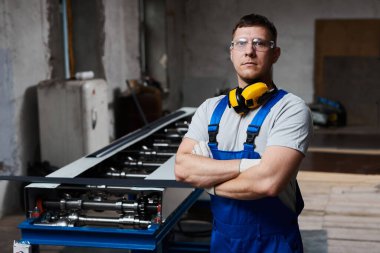 Mavi üniformalı profesyonel mühendis fabrikada çalışıyor. Yuvarlak metal, metal işleme ve metal çit üretimi