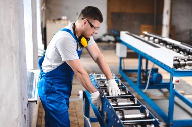 Mavi üniformalı profesyonel mühendis fabrikada çalışıyor. Yuvarlak metal, metal işleme ve metal çit üretimi
