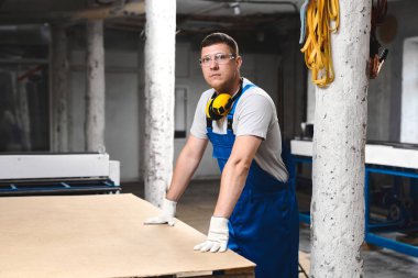 Mavi üniformalı profesyonel mühendis fabrikada çalışıyor. Yuvarlak metal, metal işleme ve metal çit üretimi