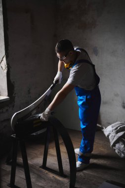 Mavi üniformalı profesyonel mühendis fabrikada çalışıyor. Yuvarlak metal, metal işleme ve metal çit üretimi