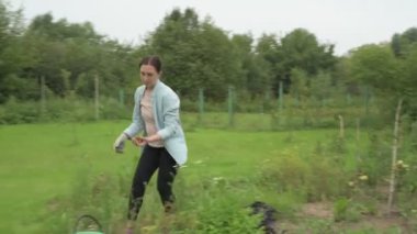 Anne ve kız bahçede çalışıyor, arka bahçedeki bitkilerle ilgileniyor, yatakları hasat ediyor ve yabani otları temizliyor.