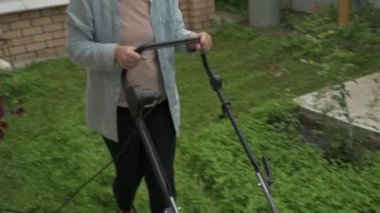 Anne ve kız bahçede çalışıyor, arka bahçedeki bitkilerle ilgileniyor, yatakları hasat ediyor ve yabani otları temizliyor.