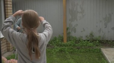 Anne ve kız bahçede çalışıyor, arka bahçedeki bitkilerle ilgileniyor, yatakları hasat ediyor ve yabani otları temizliyor.