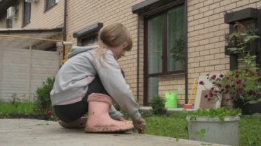 Bahçedeki küçük bir kız bahçe yatağından sebze yiyor.