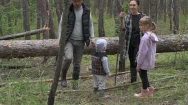 Dört kişilik mutlu bir aile ormanda yürür, mantar, böğürtlen ve ot toplar.