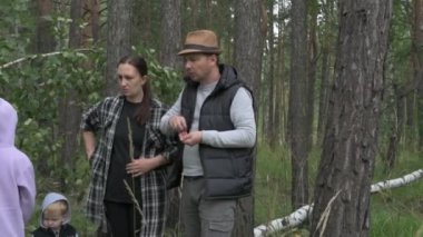 Dört kişilik mutlu bir aile ormanda yürür, mantar, böğürtlen ve ot toplar.