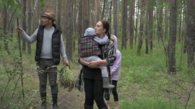 Dört kişilik mutlu bir aile ormanda yürür, mantar, böğürtlen ve ot toplar.