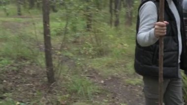 Dört kişilik mutlu bir aile ormanda yürür, mantar, böğürtlen ve ot toplar.