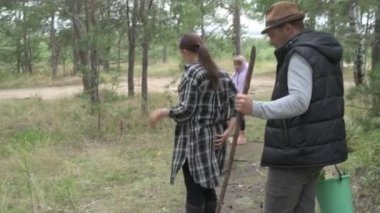 Dört kişilik mutlu bir aile ormanda yürür, mantar, böğürtlen ve ot toplar.