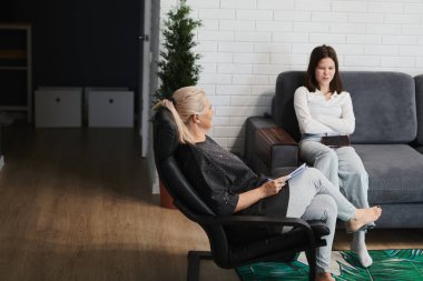 Liseli kız, rahat bir ofiste çocuk psikoterapisti ile psikolojik bir seansta.