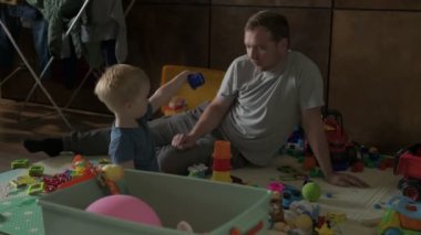 Mutlu aile babası ve küçük oğlu evde birlikte vakit geçirir, oyunlar oynar ve çizgi film izlerler.