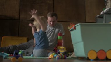 Mutlu aile babası ve küçük oğlu evde birlikte vakit geçirir, oyunlar oynar ve çizgi film izlerler.