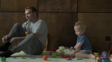 Mutlu aile babası ve küçük oğlu evde birlikte vakit geçirir, oyunlar oynar ve çizgi film izlerler.