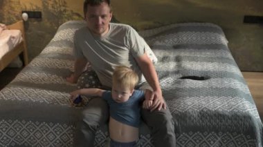 Mutlu aile babası ve küçük oğlu evde birlikte vakit geçirir, oyunlar oynar ve çizgi film izlerler.