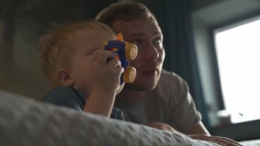 Mutlu aile babası ve küçük oğlu evde birlikte vakit geçirir, oyunlar oynar ve çizgi film izlerler.