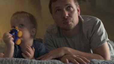 Mutlu aile babası ve küçük oğlu evde birlikte vakit geçirir, oyunlar oynar ve çizgi film izlerler.