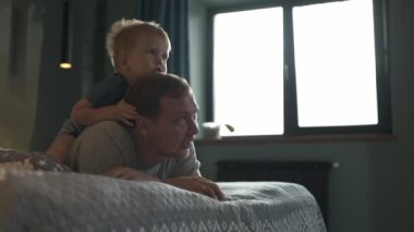 Mutlu aile babası ve küçük oğlu evde birlikte vakit geçirir, oyunlar oynar ve çizgi film izlerler.