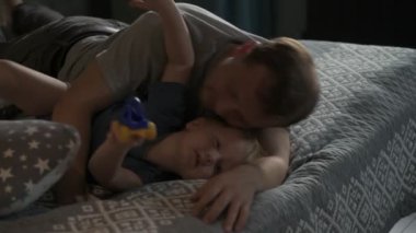 Mutlu aile babası ve küçük oğlu evde birlikte vakit geçirir, oyunlar oynar ve çizgi film izlerler.
