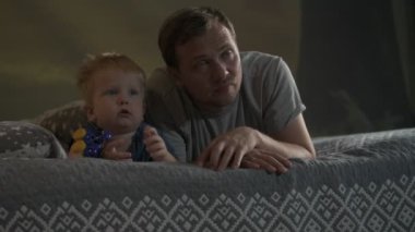 Mutlu aile babası ve küçük oğlu evde birlikte vakit geçirir, oyunlar oynar ve çizgi film izlerler.