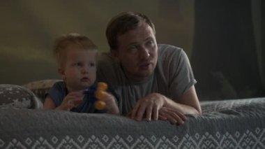 Mutlu aile babası ve küçük oğlu evde birlikte vakit geçirir, oyunlar oynar ve çizgi film izlerler.