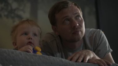 Mutlu aile babası ve küçük oğlu evde birlikte vakit geçirir, oyunlar oynar ve çizgi film izlerler.