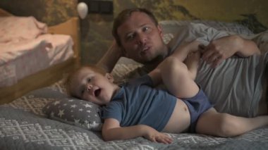 Mutlu aile babası ve küçük oğlu evde birlikte vakit geçirir, oyunlar oynar ve çizgi film izlerler.