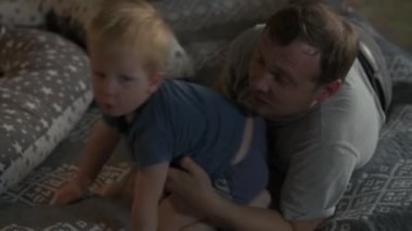 Mutlu aile babası ve küçük oğlu evde birlikte vakit geçirir, oyunlar oynar ve çizgi film izlerler.