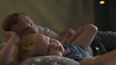 Mutlu aile babası ve küçük oğlu evde birlikte vakit geçirir, oyunlar oynar ve çizgi film izlerler.