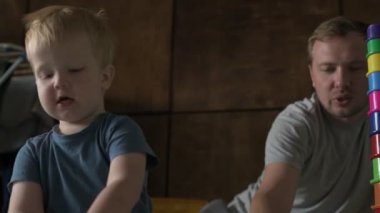 Mutlu aile babası ve küçük oğlu evde birlikte vakit geçirir, oyunlar oynar ve çizgi film izlerler.