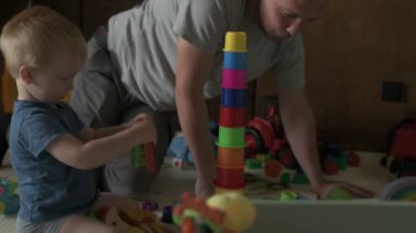 Mutlu aile babası ve küçük oğlu evde birlikte vakit geçirir, oyunlar oynar ve çizgi film izlerler.