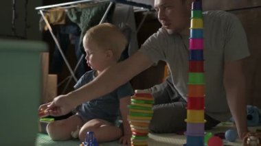 Mutlu aile babası ve küçük oğlu evde birlikte vakit geçirir, oyunlar oynar ve çizgi film izlerler.