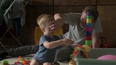 Mutlu aile babası ve küçük oğlu evde birlikte vakit geçirir, oyunlar oynar ve çizgi film izlerler.