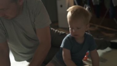 Mutlu aile babası ve küçük oğlu evde birlikte vakit geçirir, oyunlar oynar ve çizgi film izlerler.
