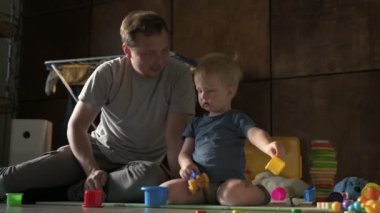 Mutlu aile babası ve küçük oğlu evde birlikte vakit geçirir, oyunlar oynar ve çizgi film izlerler.