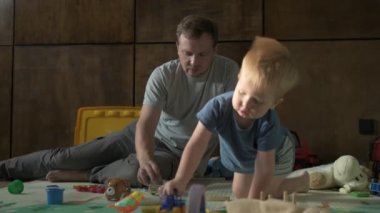 Mutlu aile babası ve küçük oğlu evde birlikte vakit geçirir, oyunlar oynar ve çizgi film izlerler.