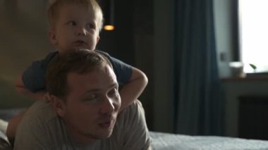 Mutlu aile babası ve küçük oğlu evde birlikte vakit geçirir, oyunlar oynar ve çizgi film izlerler.