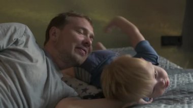 Mutlu aile babası ve küçük oğlu evde birlikte vakit geçirir, oyunlar oynar ve çizgi film izlerler.