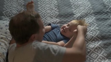 Mutlu aile babası ve küçük oğlu evde birlikte vakit geçirir, oyunlar oynar ve çizgi film izlerler.