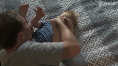 Mutlu aile babası ve küçük oğlu evde birlikte vakit geçirir, oyunlar oynar ve çizgi film izlerler.