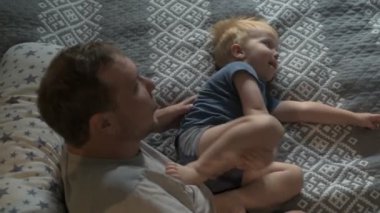 Mutlu aile babası ve küçük oğlu evde birlikte vakit geçirir, oyunlar oynar ve çizgi film izlerler.