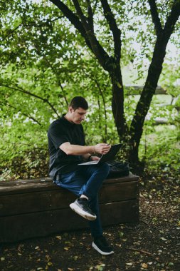 Forest Park 'ta dizüstü bilgisayarla çalışan genç programcının portresi, yazılım geliştiricisi, bilişim teknolojileri.