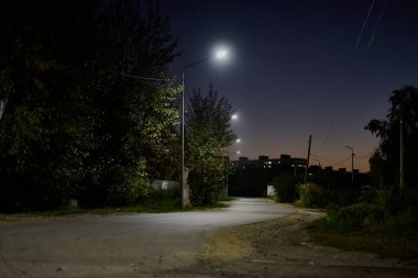 Gece şehri manzarası, köy evleri, yollar, gökyüzü ve ağaçlar bir yaz akşamında