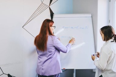 Öğrenci kız ve öğretmenin ofiste bir dersi var, özel dersler, uzaktan öğrenme.