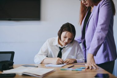 Öğrenci kız ve öğretmenin ofiste bir dersi var, özel dersler, uzaktan öğrenme.