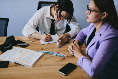 Öğrenci kız ve öğretmenin ofiste bir dersi var, özel dersler, uzaktan öğrenme.
