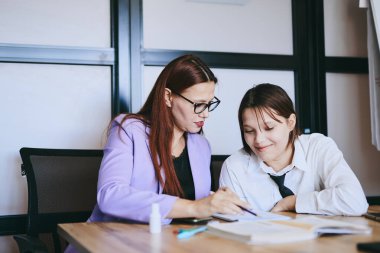 Öğrenci kız ve öğretmenin ofiste bir dersi var, özel dersler, uzaktan öğrenme.