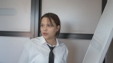 Matematik sınıfında üniformalı bir kız tahtaya resim çiziyor.