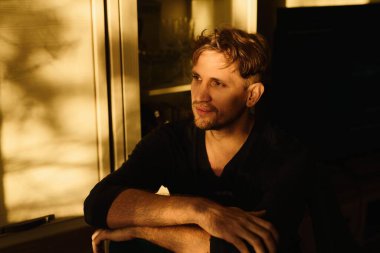 Dairenin arka planında gülümseyen yakışıklı beyaz adamın yakın plan portresi.