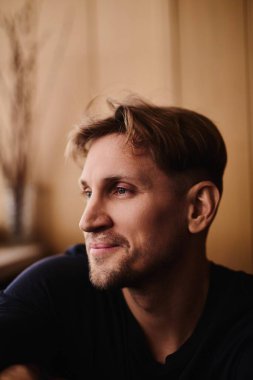 Dairenin arka planında gülümseyen yakışıklı beyaz adamın yakın plan portresi.